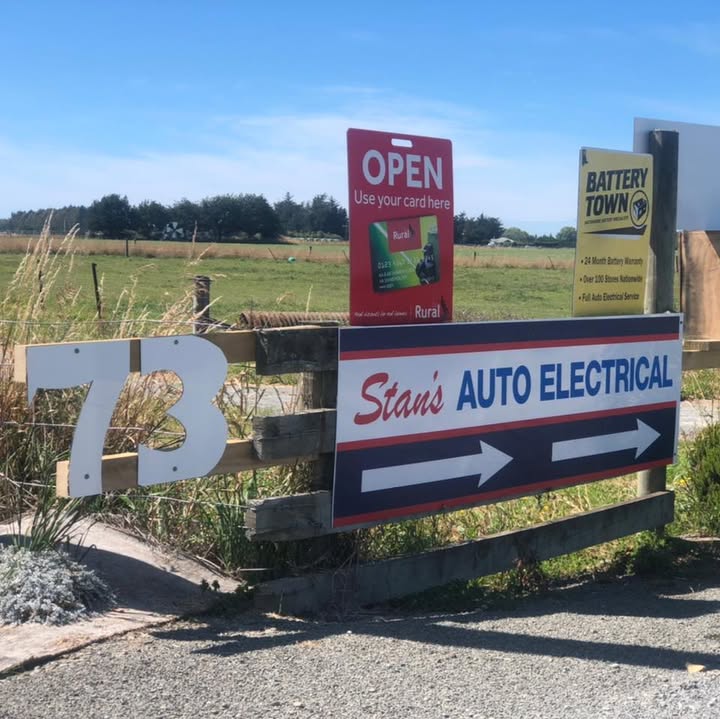 The Stan's Auto Electrical sign at the gate of 73 Kennels Road, with Battery Town and Ruralco signs and paddocks behind